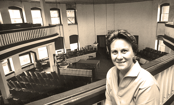 photo of To Kill A Mockingbird author Harper Lee sitting in balcony of Monroe County Courthouse in Monroeville, Alabama where her trial lawyer father had argued cases