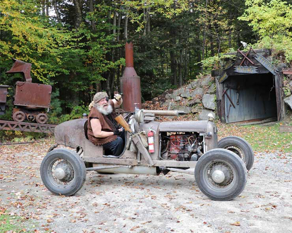The Wolfman in junky rusty old car made spare parts telling train passengers to get off his land at Clark's Bears amusement park roadside attraction Lincoln NH