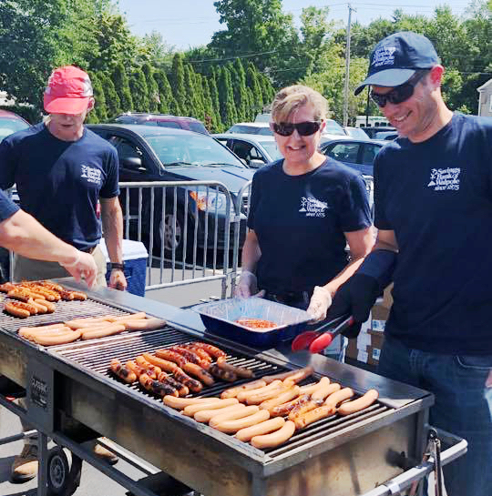 Savings Bank of Walpole employees cooking hot dogs in their parking lot for Customer Appreciation Day in Keene, NH